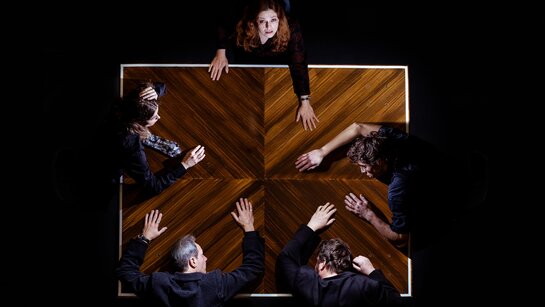 Hedwig Schuster (Sara Nunius), die immer noch den Jubel vom Heldenplatz hört, am Tisch mit Herrn Landauer (Tommy Fischnaller-Wachtler), Prof. Liebig (Philipp Rudig), Prof. Robert Schuster (Christoph Kail) und Anna (Julia Posch).