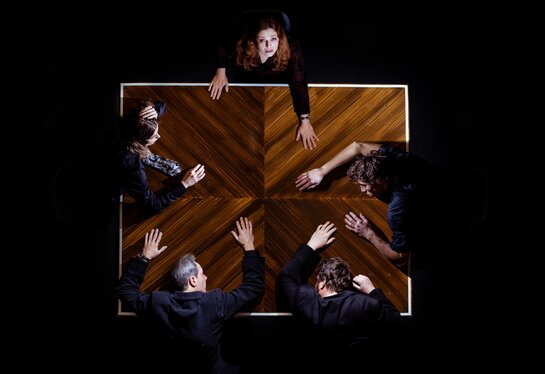 Hedwig Schuster (Sara Nunius), die immer noch den Jubel vom Heldenplatz hört, am Tisch mit Herrn Landauer (Tommy Fischnaller-Wachtler), Prof. Liebig (Philipp Rudig), Prof. Robert Schuster (Christoph Kail) und Anna (Julia Posch).